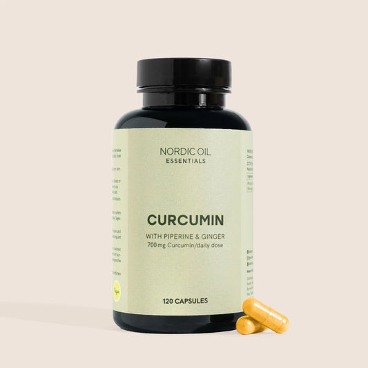 Nordic Oil Essentials Curcumin -kapsulipurkki ja kaksi keltaista kapselia vieressä