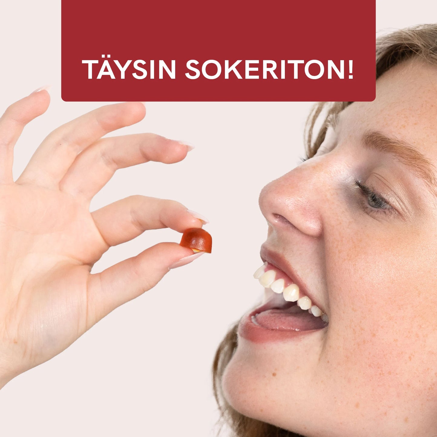 Nainen pitelee oranssia kapselia sormenpäillään suun edessä