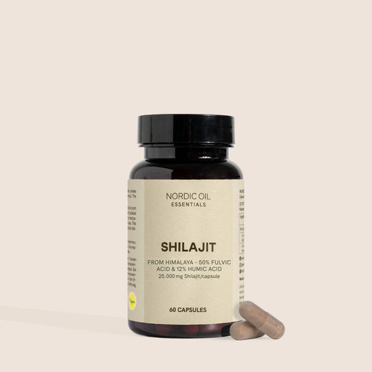 Shilajit-kapselipurkki Nordic Oil Essentials -etiketillä ja kaksi kapselia vieressä.