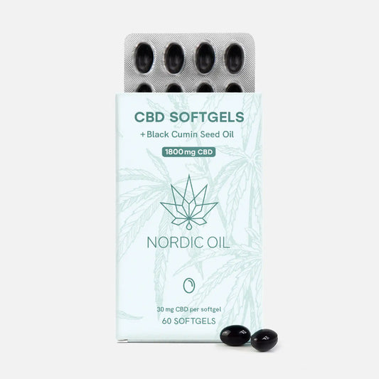 Nordic Oil CBD-softgelit -pakkaus, mustat kapselit blisterissä ja hampunlehtikuvio taustalla