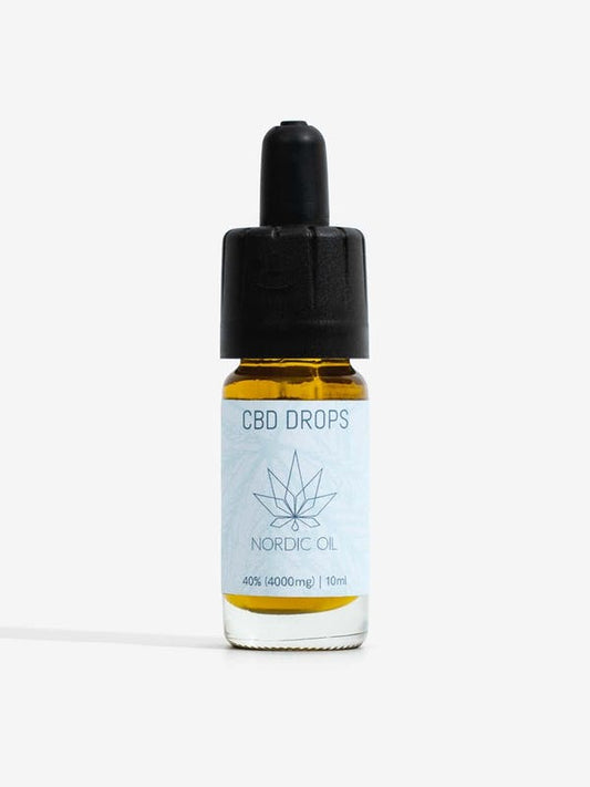 CBD-öljytippipullo Nordic Oil sinisellä etikettillä ja kannabiksen lehden kuvio
