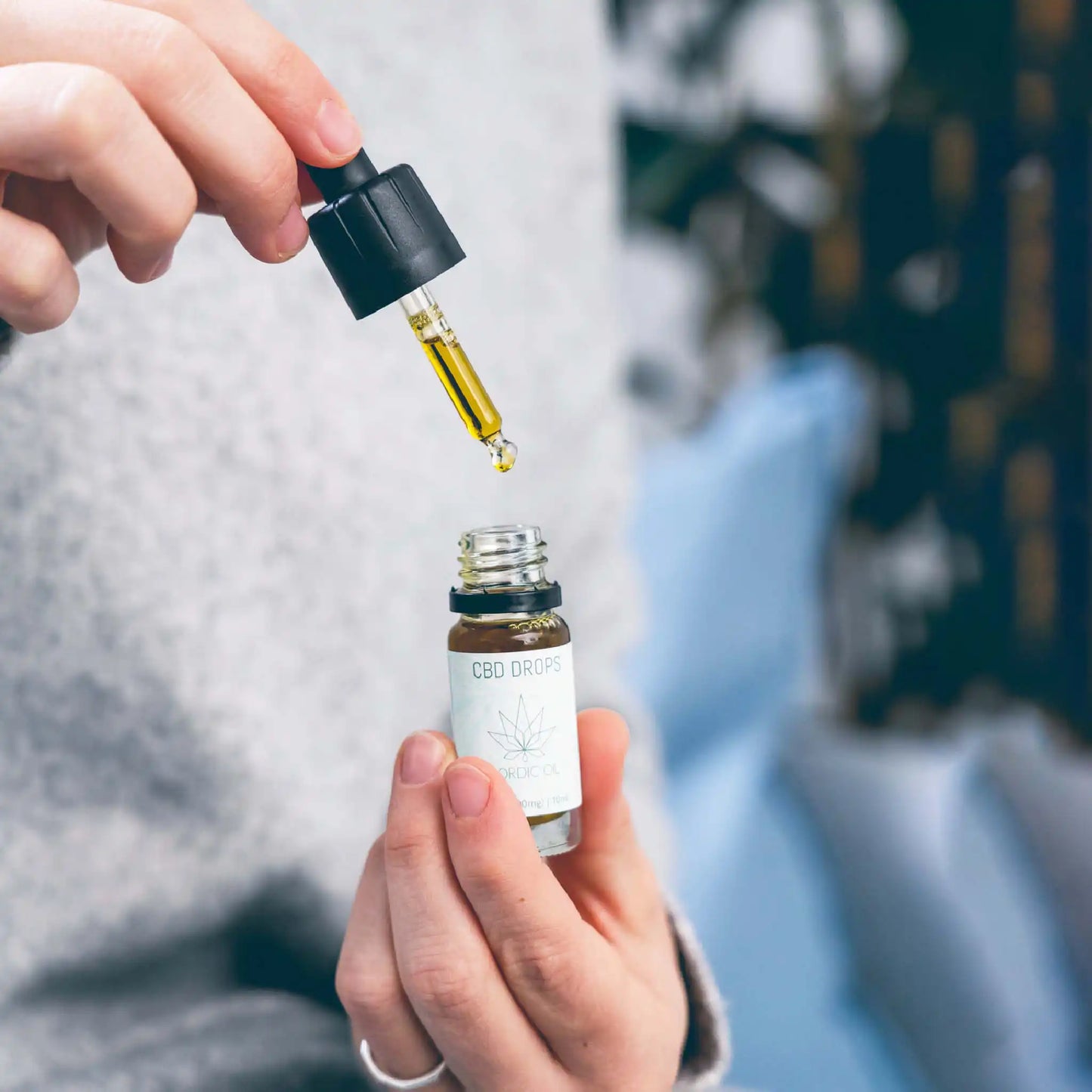 Nainen pitelee pulloa 10ml Nordic Oilin laajakirjoista CBD-öljyä.