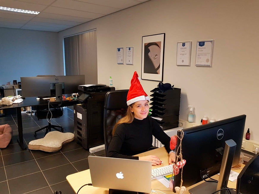 Nainen istuu toimistossa jouluhattu päässään.