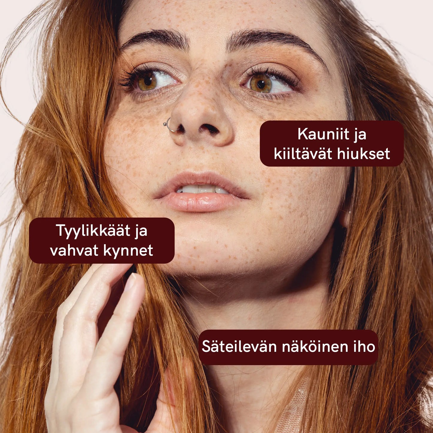Naisen kasvokuva lähellä, näkyy pisamia ja pitkät hiukset; kuvassa kolme maroon-tekstilaatikkoa: Kauniit ja kiiltävät hiukset, Tyylikkäät ja vahvat kynnet sekä Säteilevän näköinen iho.