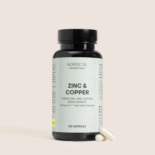 Nordic Oil Essentials Zinc & Copper -kapselipullo ja kaksi valkoista kapselia sen vieressä.